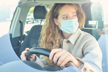 Crop woman in face mask driving modern car in city / Photodune, Misc