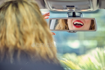 Crop joyful woman looking in car rearview mirror / Photodune, Misc