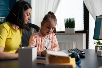 Mother helping young daughter with school homework / Photodune, Misc