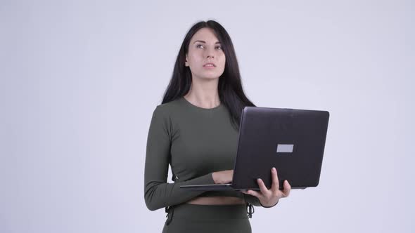 Happy Young Beautiful Woman Thinking While Using Laptop