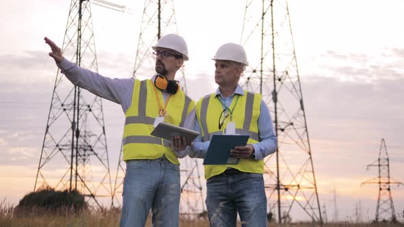 Workers Check Power Lines in Field
