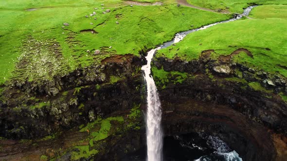 Aerial view of Mulafossur waterfall near a small village, Faroe island.