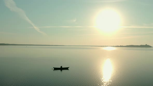Aerial Drone View of Fisherman on the Boat on the Sunrise, Morning Fishing, Swimming on a Calm Lake