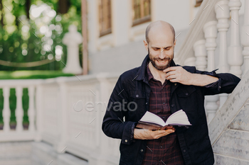 Clever middle aged student learns and cramps information before final exam, focused in book / Photodune, Misc