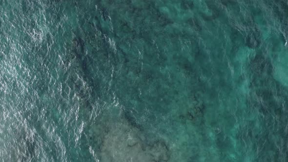 Aerial view from above of the turquoise green water of the Pacific Ocean creating a beautiful textur