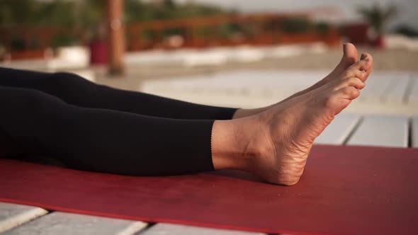 Athletic Woman Practicing Yoga on Mat on the Beach Performing Yoga Elements Upwards Plank