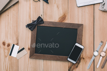 top view of smartphone with blank screen, empty photo frame with bow tie, credit cards and / Photodune, Misc