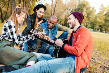 group of happy multicultural friends resting in park together / Photodune, Misc