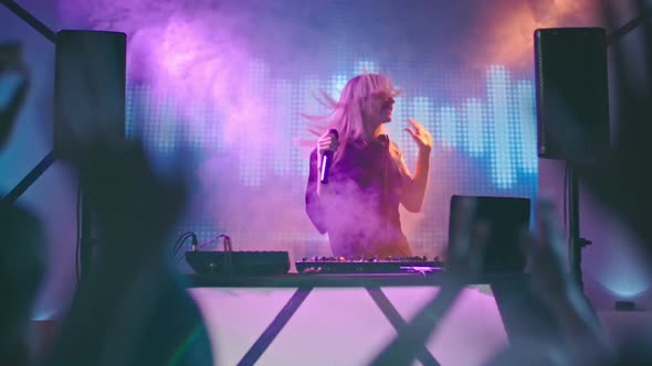 Young Female DJ Singing in Nightclub