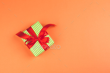 Present with a bow on orange background / Photodune, Misc