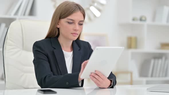 Serious Professional Businesswoman Using Tablet in Office
