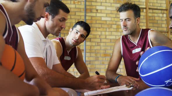 Coach assisting players on clipboard clipboard