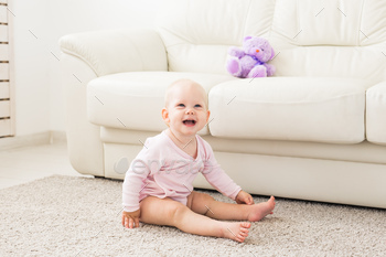 childhood, babyhood and people concept - happy little baby girl sitting on floor at home / Photodune, Misc