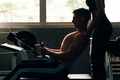 Young man at gym, training hard and pulling weights in seated cable row machine - PhotoDune Item for Sale