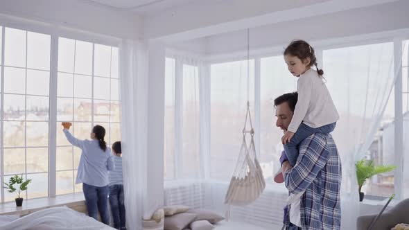 Man Washing Floor with Daughter on His Shoulders