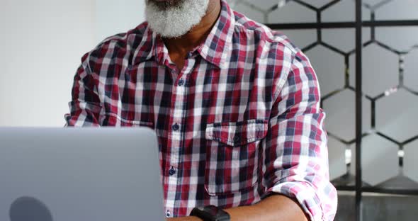 Senior Male Executive Using Laptop at Desk