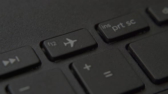 The Finger Presses the "Airplane" Button on the Keyboard