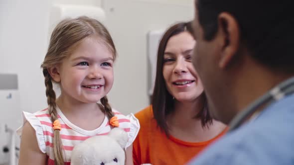 Laughing Girl and Mother Talking with Doctor