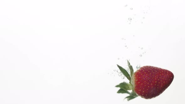 A Slow Motion of a Strawberry Being Dropped in a Clear Water