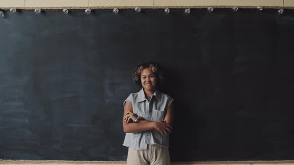 Young Woman Posing by Blackboard