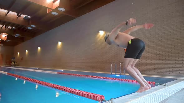 Male Swimmer Jumping Into Swimming Pool in Slow Motion