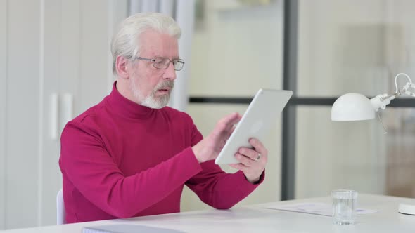 Old Man Using Tablet at Work