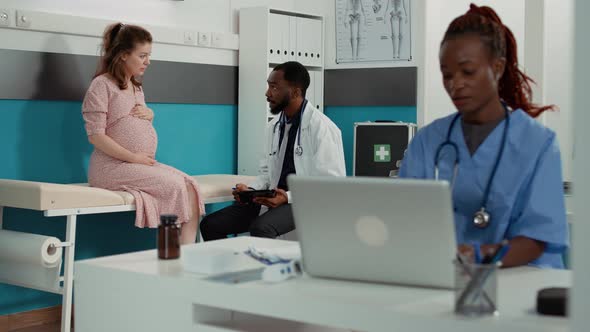 Obstetrician Taking Notes on Digital Tablet About Maternity