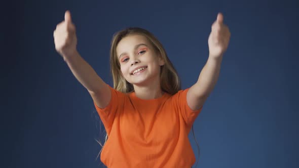 A Young Teenage Girl Shows a Thumbs Up Gesture