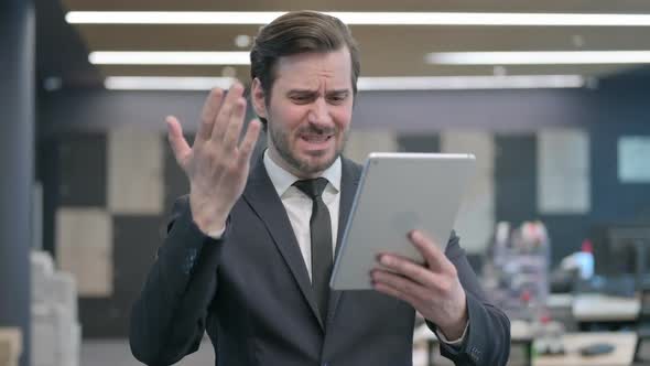 Portrait of Businessman Having Loss on Tablet in Office