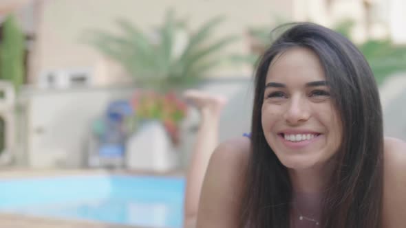 amazing young woman laying on the edge of a pool