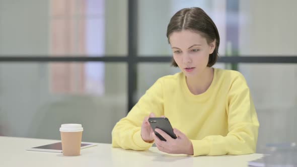 Successful Young Woman Celebrating on Smartphone