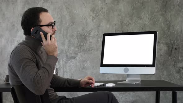 Architect Talking on the Phone Discussing the Project on the Screen of the Computer