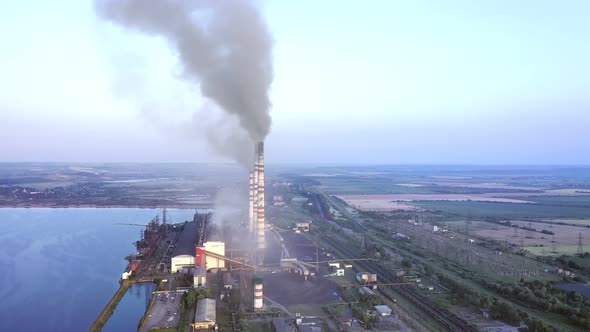 Aerial view of coal power plant high pipes with black smoke moving up polluting atmosphere