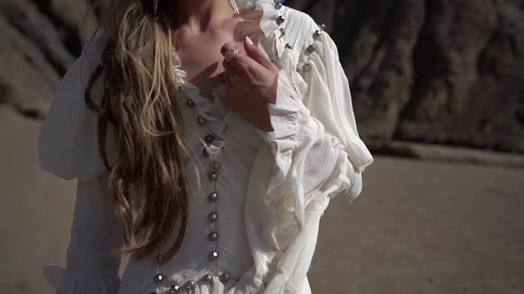 Lonely Pretty Woman Is Posing in Desert at Sunny Day, Dressed White Gown, Calm and Romantic