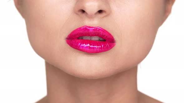 Extreme Close Up Portrait of Seductive Female Person 30s Biting Her Lower Lip Covered with Pink