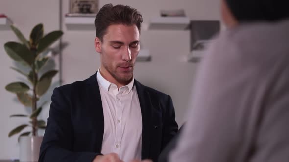 Man and Woman Having Talk and Shaking Hands During Business Meeting at Table in Modern Office Spbi