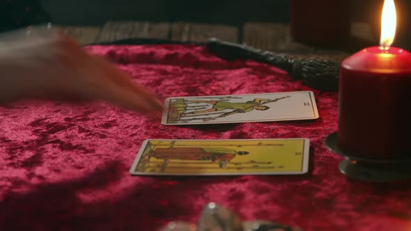 A Fortune Teller Lays Out Seven Tarot Cards on a Burgundy Tablecloth