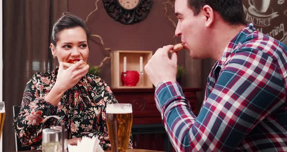 Couple Eats Pizza and Drinks Beer