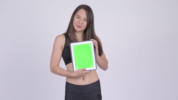 Young Happy Multi-ethnic Woman Showing Digital Tablet Ready for Gym