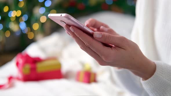 Close Up Woman Hands Using Mobile Phone on Christmas Background