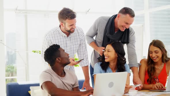 Team of executives interacting with each other while working in the office