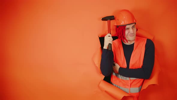 Builder with Red Dreadlocks He Thinks and Scratches His Helmet with a Hammer Trying to Remember