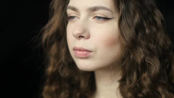 A Calm and Meditative Girl Shakes Her Hair and Smiles Shyly. Close-up in Slowmo