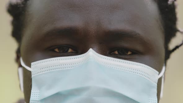 Close Up Shot of an African Man with Medical Mask Over the Face in the Park