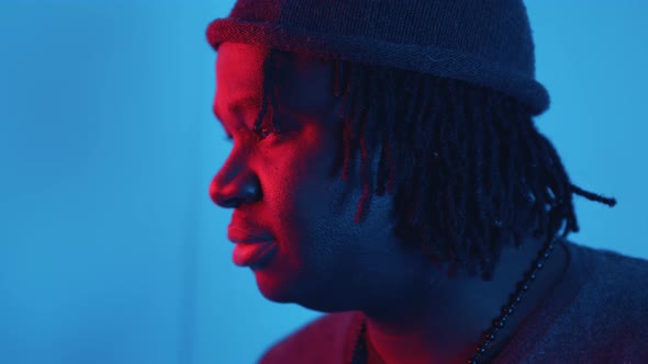 Profile of Young African American Black Man with Dreadlocks Lit with Red and Blue Light