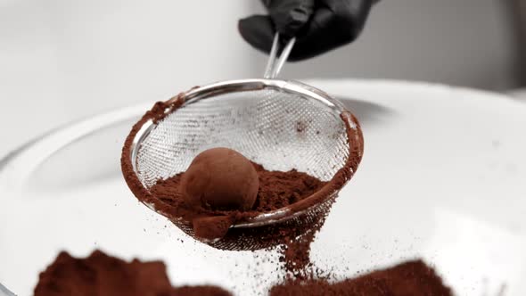 Pastry Chef Pours Truffle Candy in Cocoa Powder Using Strainer Slow Mo Close Up