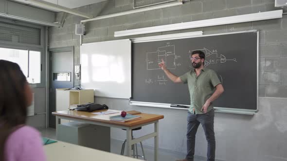 High School Teacher Explaining Electronics Circuits To Pupils Learning In Technology Course