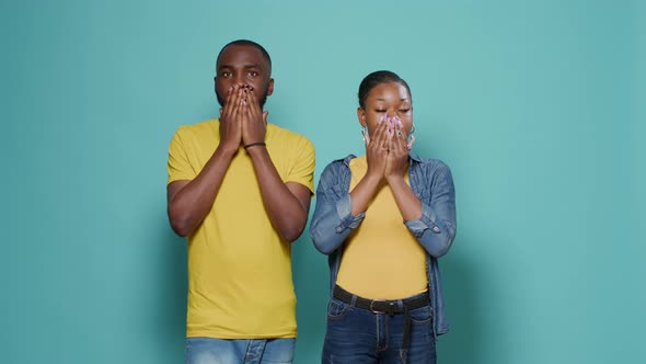 Shocked Man and Woman Covering Mouth Eyes and Ears in Front of Camera