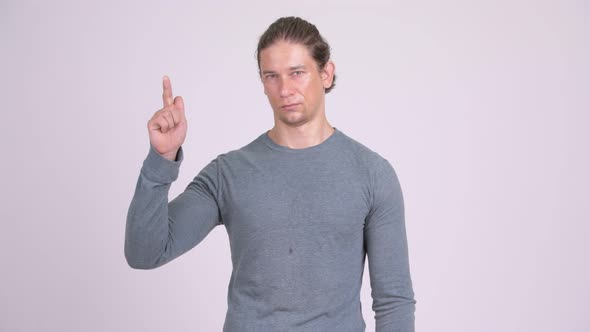 Handsome Man Pointing Finger Up Against White Background