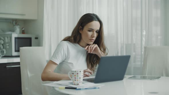 Happy Woman Working Laptop Computer at Home. Excited Woman Reading Good News